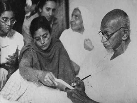 Gandhiji writing something at the time of his last fast at Birla House in New Delhi. Manu Gandhi and Ava Gandhi are also seen in this photograph.jpg